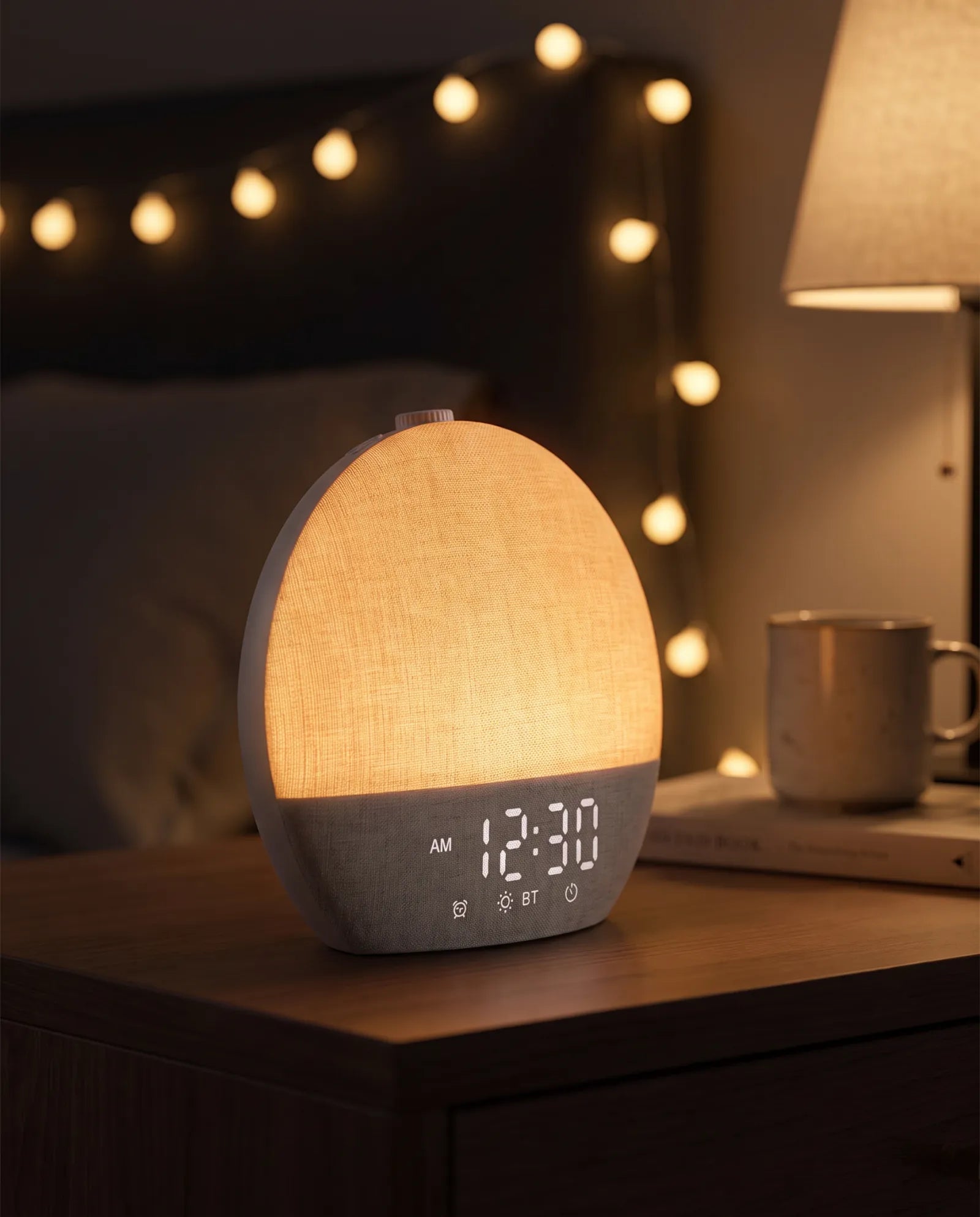 The Aploomb sound machine in use, glowing warm amber on a nightstand at night